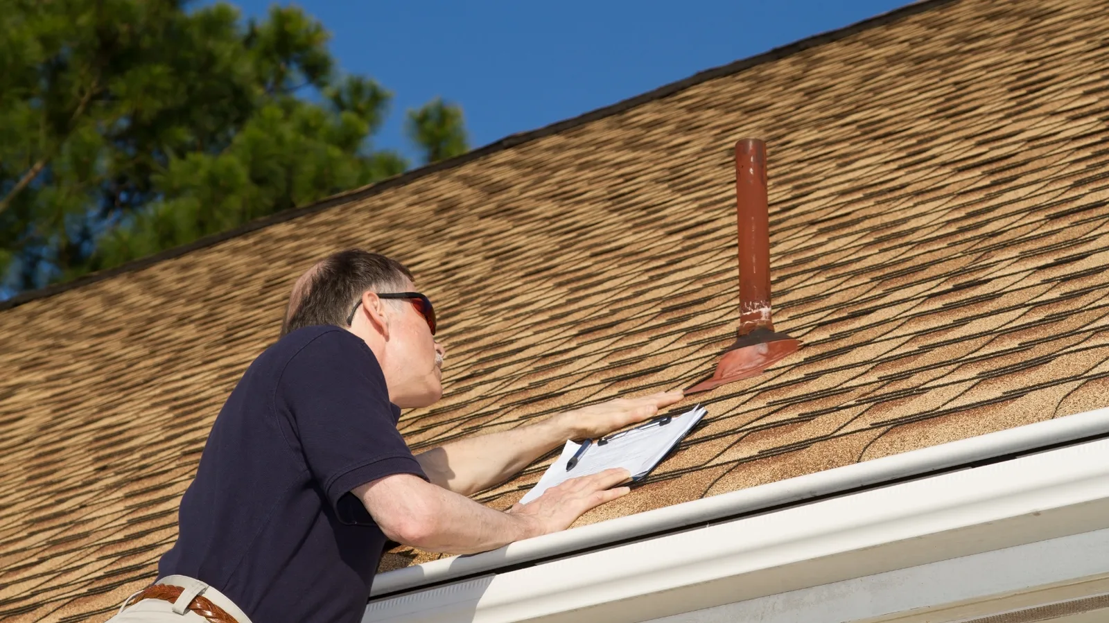 A roof inspection beside a vent pipe and its flashing base